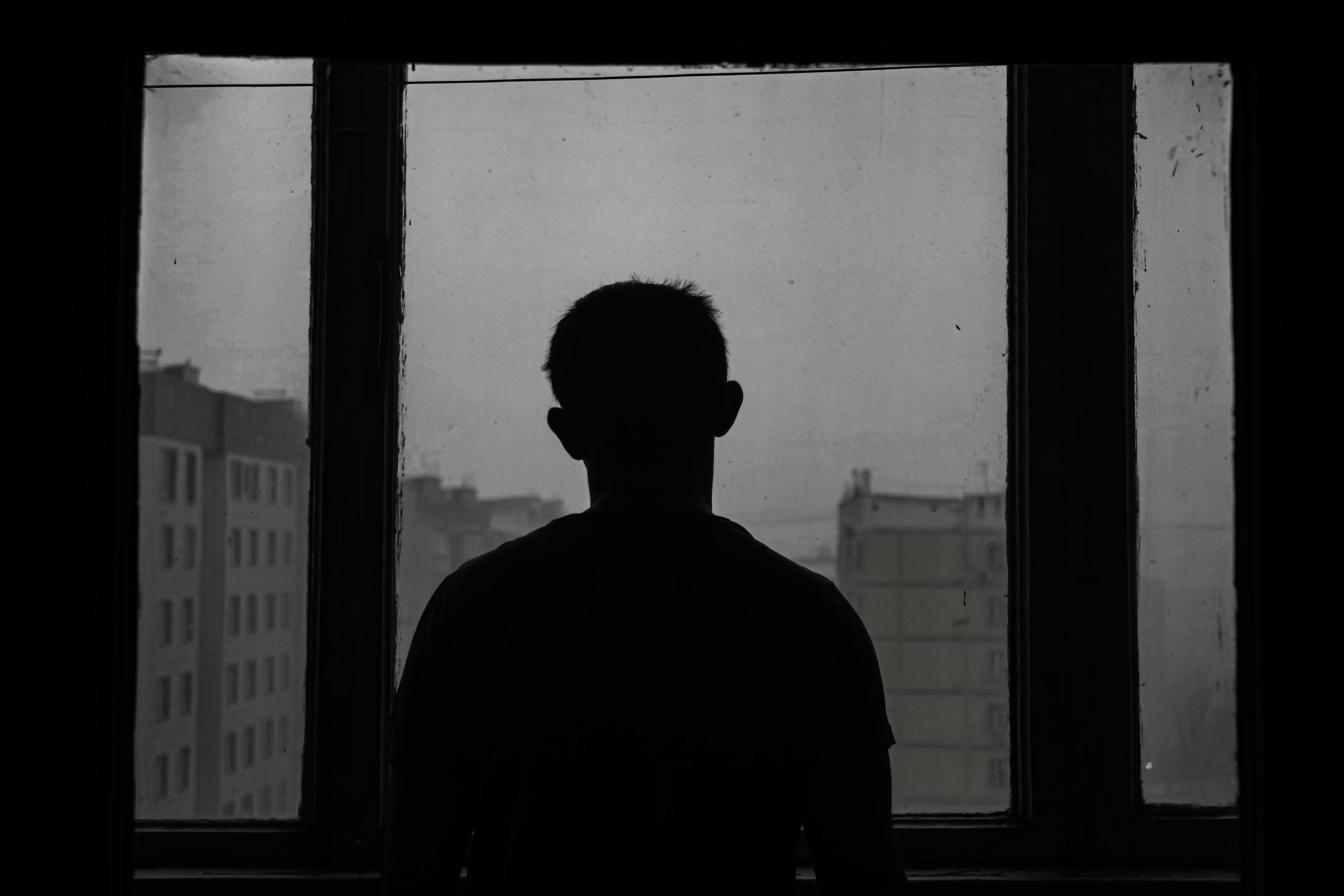 melancholic man staring out the window